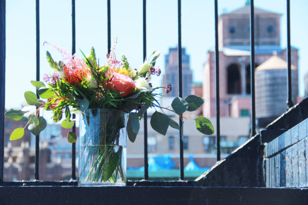 Artificial flowers in white vase on blur nature background.