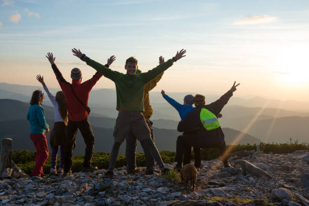 istock Happy hikers, friends with open arms are standing on a top 933283336