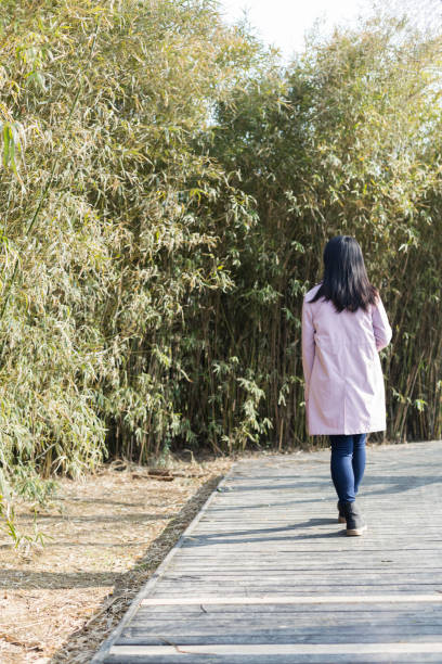 istock young female holding disposable cup walking on park trail 933294748
