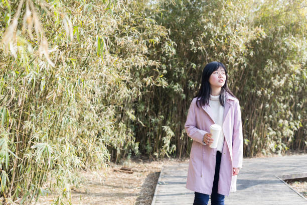 istock young female holding disposable cup walking on park trail 933294750