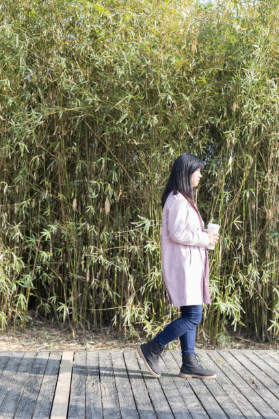 istock young female holding disposable cup walking on park trail 933295242