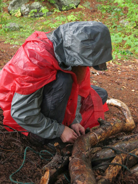 istock Bearded Glasses Man, Red Rain jacket, Bundling Campfire Wood 933302528
