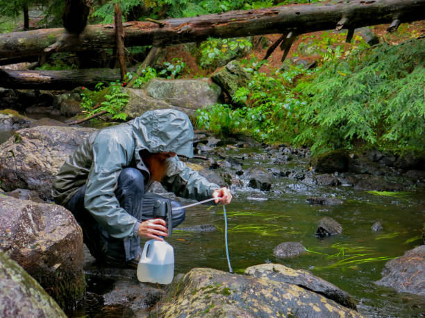 istock Survivalist Bearded Mountain Man Purifying Stream Water, Adirondacks, NY 933307524