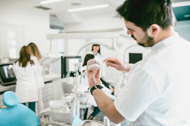 istock Young Doctor Shows the Wright Way To Brush Your Teeth with Dentures 933309970