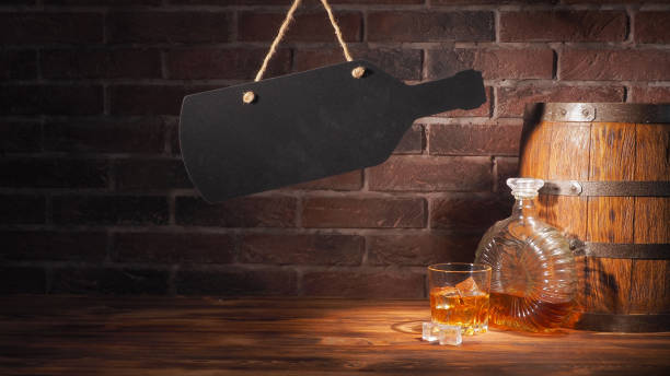 istock Glass of cognac with barrel on brick backgroun 933312462