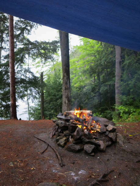 istock Camping in Rain, Campfire Flames, Tarp Survivalist Shelter 933312692