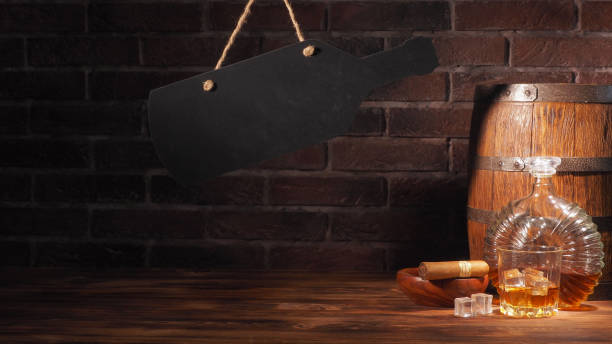 istock Glass of cognac with barrel on brick backgroun 933312910