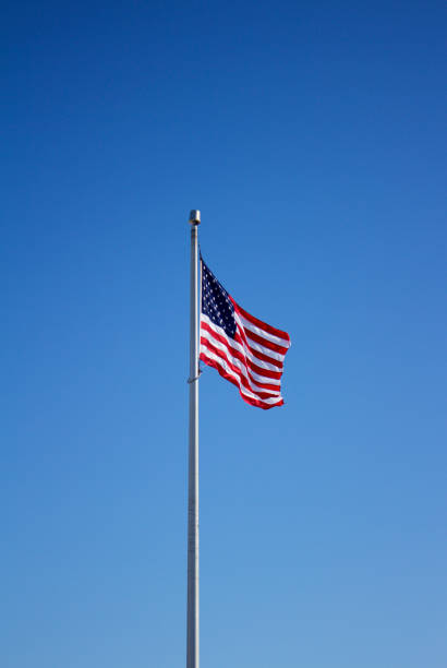 istock American flag on flagpole with blue sky background 933318582