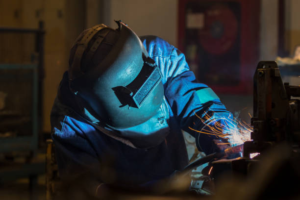 istock Worker at the factory is welding assembly automotive part 933323708