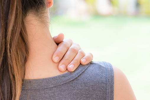 Closeup woman neck and shoulder pain and injury. Health care and medical concept.