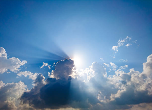 istock White fluffy clouds and sun reflect, in the blue sky 933347896