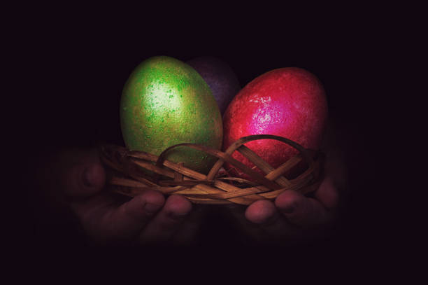 Close up of colorful Easter eggs in a basket Close up of colorful Easter eggs in a basket. painted eggs in baby's hand at night on black background. in green and red color goodfood stock pictures, royalty-free photos & images