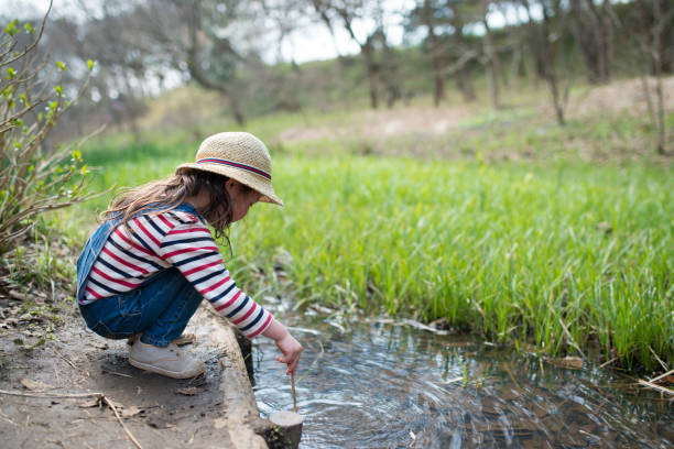 istock Little girl playing in the creek 933365216