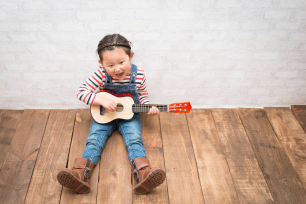 istock Little girl playing the guitar 933370848