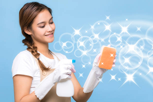 Young woman holding a cleanser spray.