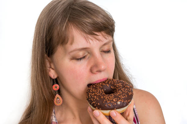 istock Attractive woman is eating a delicious donut 933380762