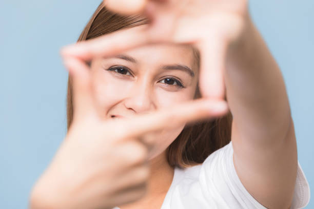 istock Young woman making picture frame by her hand. 933381086