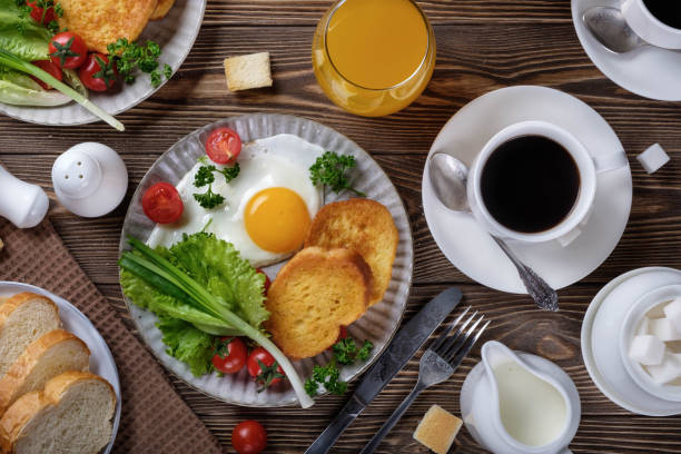 istock Fried eggs, croutons and salad with coffee and orange juice. 933383732