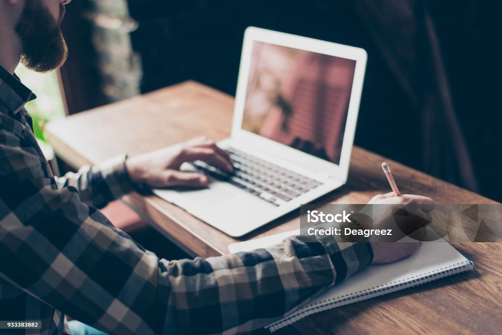 People management employment marketing modern technology concept. Cropped close up photo of smart intelligent focused concentrated clever guy doing home task writing information to copybook Internet Stock Photo