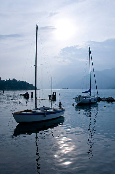 Pedal boats lined up along the shore of lake garda in riva del garda, italy
