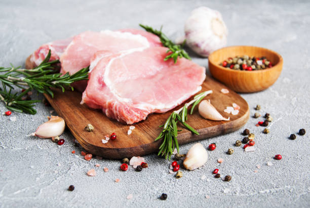 istock Fresh raw pork chops with spices and herbs 933389308