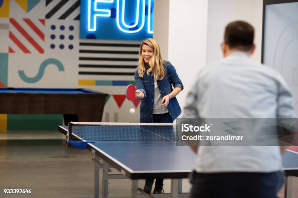 Young Woman Playing Table Tennis With Her Colleague Stock Photo - Download Image Now