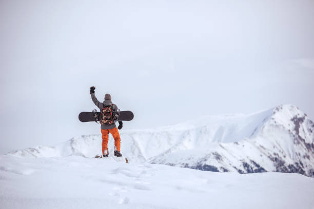 istock Snowboarder stands on mountain top ski tour concept 933393250