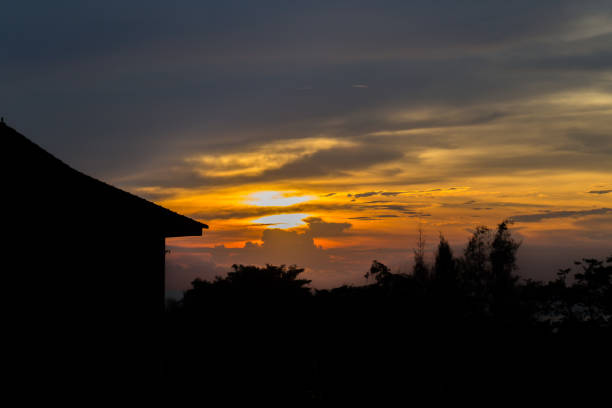 istock Silhouette home and tree with beautiful sunset 933407558