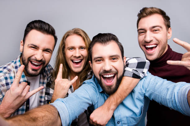 istock Ethnicity diversity masculinity socialization lifestyle leisure laughter winner entertainment concept. Close up photo of cheerful candid boys pals taking selfie isolated on gray background 933408294
