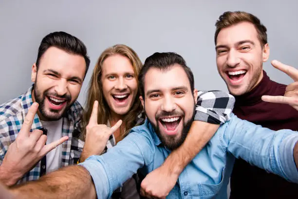 Photo of Ethnicity diversity masculinity socialization lifestyle leisure laughter winner entertainment concept. Close up photo of cheerful candid boys pals taking selfie isolated on gray background