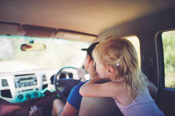 istock Young girl looking leaning forward in car 933415264
