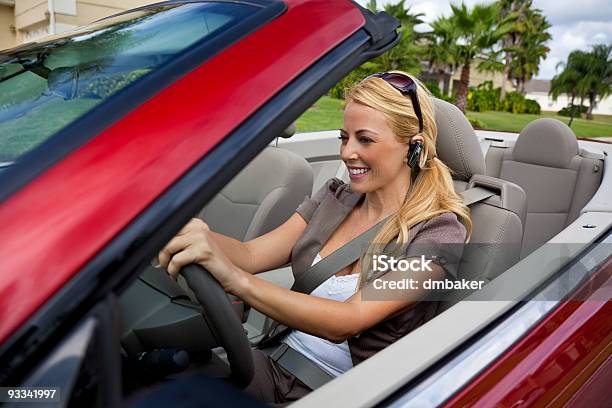 Beautiful Young Woman Driving Convertible Car Talking On Bluetooth Headset Stock Photo - Download Image Now