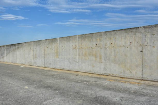 istock straight concrete border or prison wall 933421514