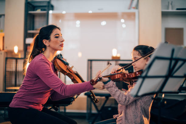 istock Little girl learning to play violin 933422268