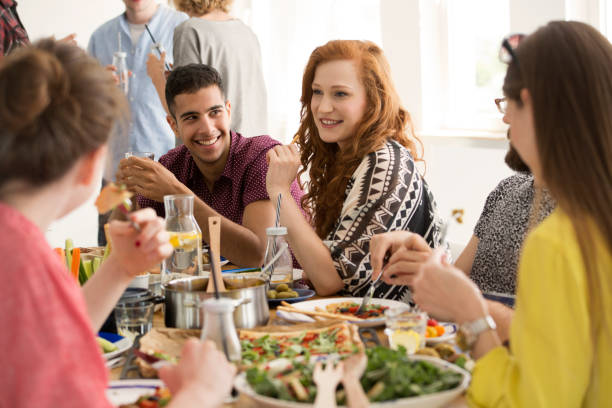 Smiling red-haired woman eating dinner