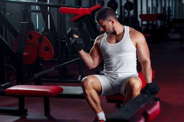 istock Young man exercising with weight in the gym. 933431918