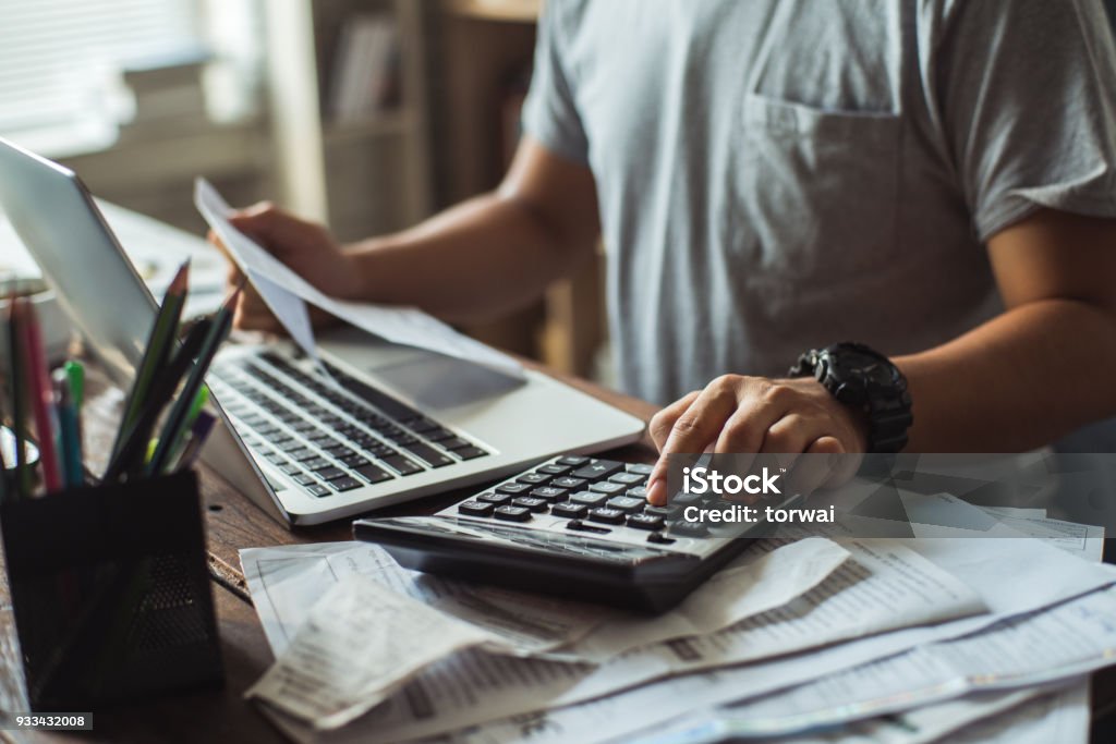 Men is calculating the cost of the bill. She is pressing the calculator. Financial Bill Stock Photo