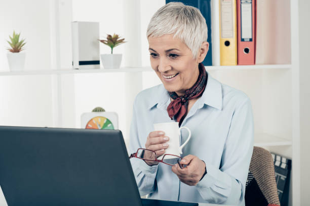 istock Enthusiastic business woman sips coffee and looks at computer 933434250