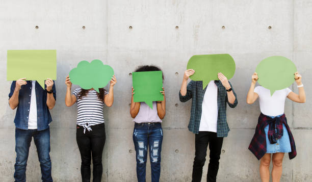 istock Group of young adults outdoors holding empty placard copyspace thought bubbles 933442552