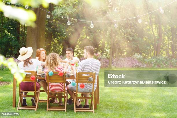 Smiling Friends During Garden Party Stock Photo - Download Image Now - Summer, Patio, Party - Social Event