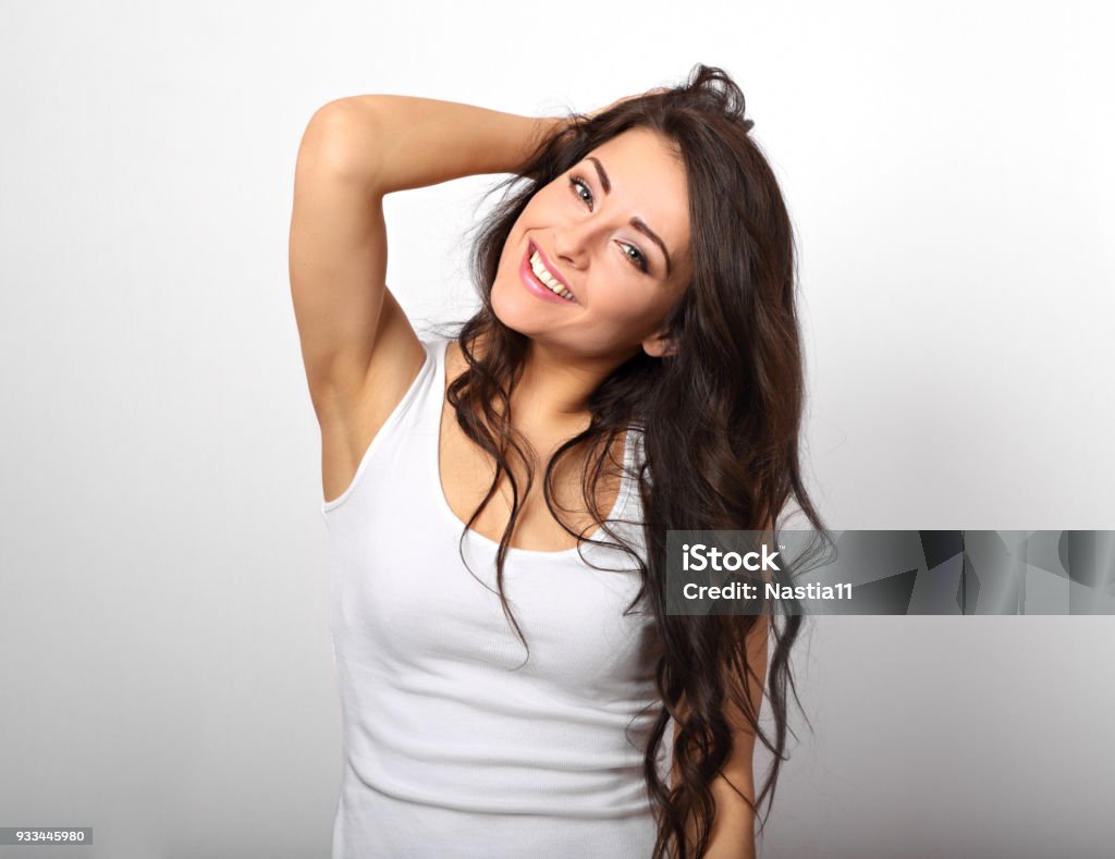 Beautiful positive fun happy woman in white shirt with toothy smile showing her epilation armpit on white background Under the Arm Stock Photo