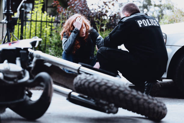 Policeman interviewing motorbike driver Policeman interviewing a dazed driver of a motorbike after a crash concussion photos stock pictures, royalty-free photos & images