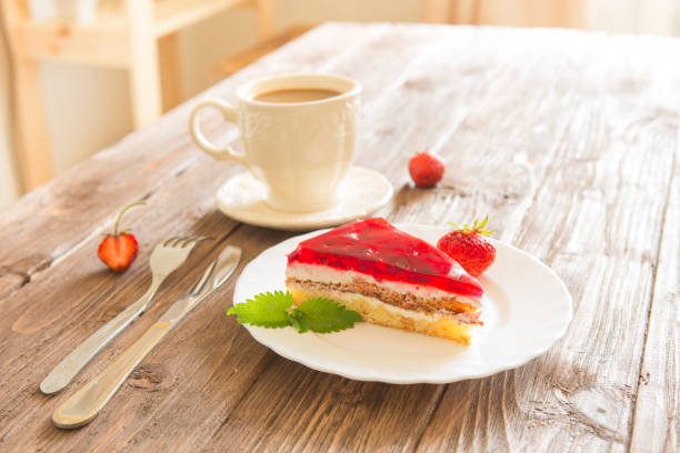 istock Strawberry tart on plate with coffee on wooden table 933457374