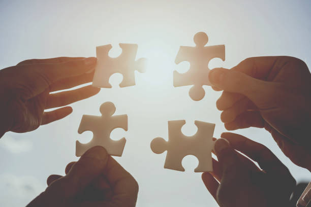 istock Businesspeople holding puzzle 933458146