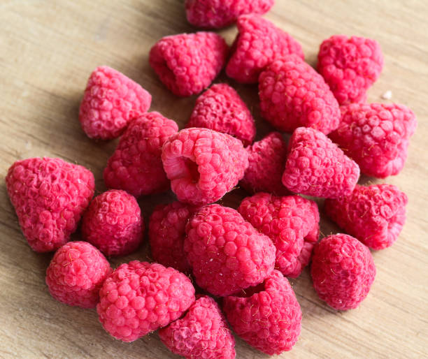 istock Frozen sweet eye raspberries on wooden background 933461476