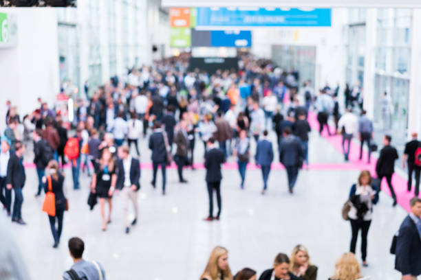 blurred anonymous people walking blurred anonymous people walking in a modern hall exhibition stock pictures, royalty-free photos & images