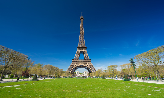 Beautiful garden in spring at the feet of Eiffel Tower in Paris. Panorama image.