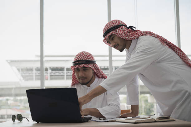 istock Two Businessman Arab men sitting working with a laptop. they are business analyzing,discussing. brainstorming, teamwork, meeting concept. 933469574