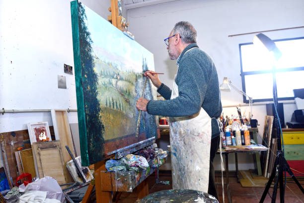 istock Painter artist painting a picture in the studio 933470032