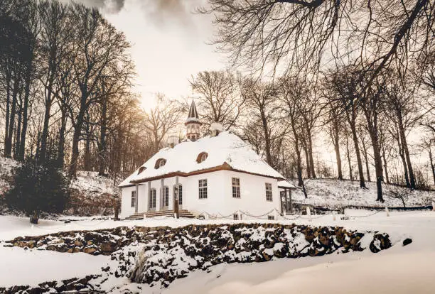 Winter season at Liselund park on the island of Møn in Denmark. Colour, horizontal with some copy space. Set in a public park the fairy tale like buildings within it become more magical when the snow starts to fall.